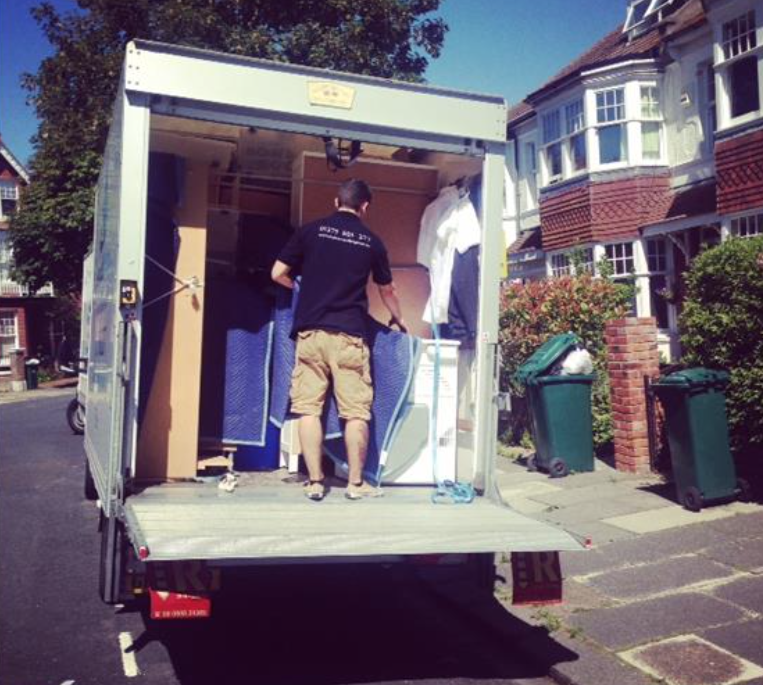 Removals Brighton mover loading van on a sunny Brighton residential street