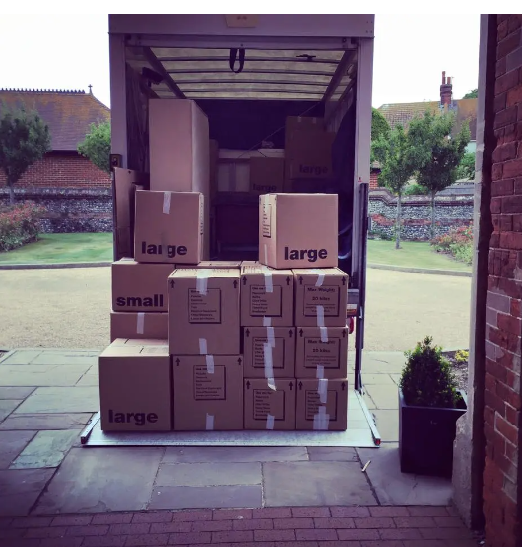Large and small moving boxes packed neatly on van tailgate at a Sussex property