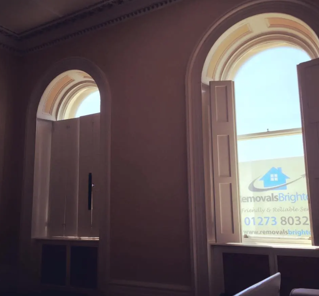 Empty Regency room in Brighton with Removals Brighton van visible through window